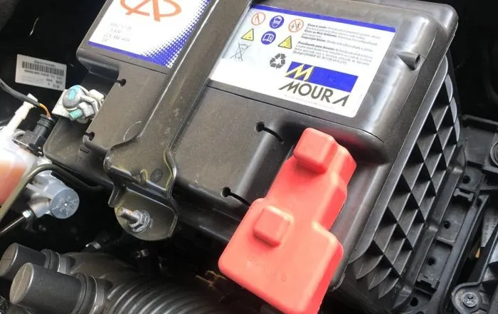 Bateria Moura nova instalada, com capa vermelha no terminal positivo